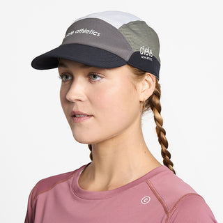side view of ciele athletics FSTCap SC Field Iconic SL unisex running hat in whitaker color on a model