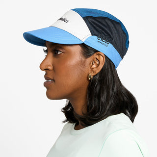 side view of the ciele athletics FTSCap unisex running hat in white cobalt color, on a model