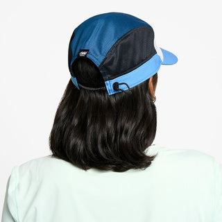 back view of the ciele athletics FTSCap unisex running hat in white cobalt color, on a model