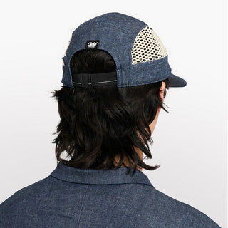 back view of ciele athletics GOCap longbrim unisex running hat with longer brim from the Lifestyle Edition collection, in denim indigo color, on a model